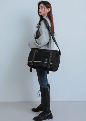 wearing a black shoulder bag against a plain background at K* Marketplace