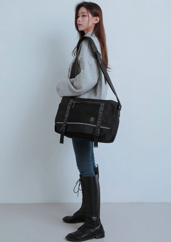 wearing a black shoulder bag against a plain background at K* Marketplace